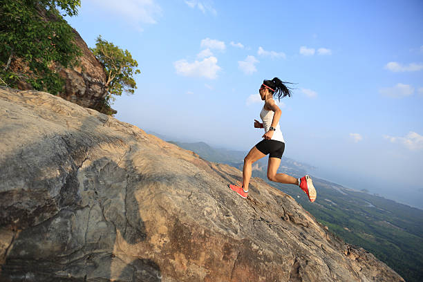 istock young asian woman runner running on mountain peak 525015206