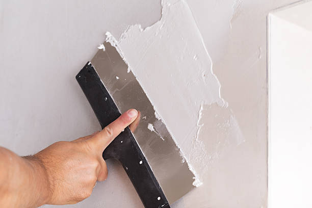 istock house improvement worker puts finishing layer of stucco on wall 525015570