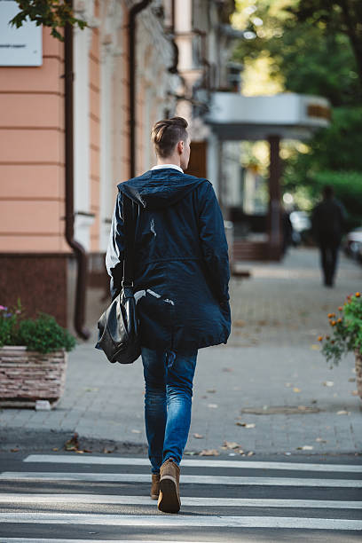 istock Young man cross the street 525016489