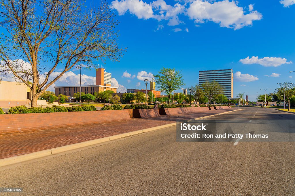 Lubbock skyline cityscape with spring foliage,TX Downtown cityscape with roadway filling the foreground leading back to Lubbock skyline with clouds above, Texas Lubbock Stock Photo