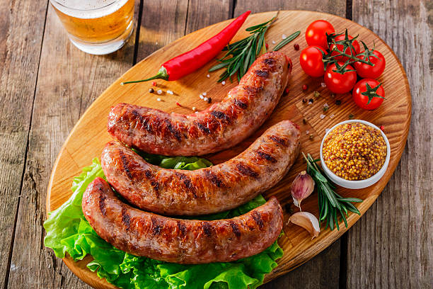 istock Grilled sausage on a board with vegetables and sauce 525020913