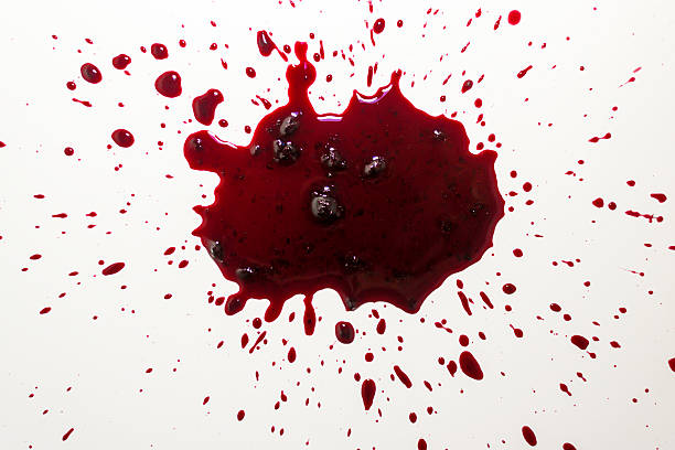 Fresh red blood splat on white porcelain with specks from the impact. Copy space area for horror themed concepts and ideas.