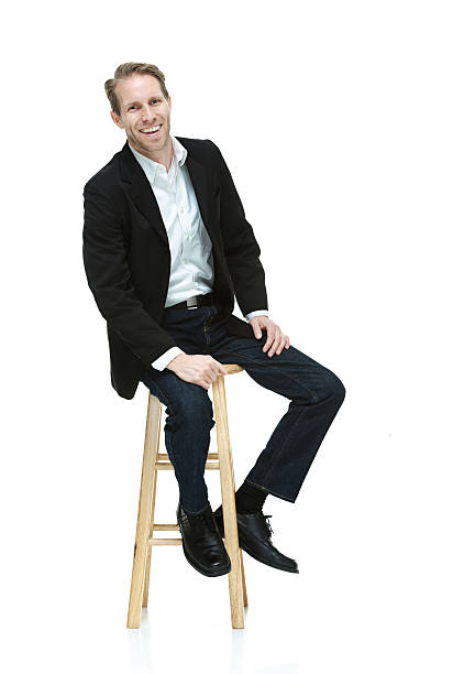 istock Smiling smart casual man sitting on stool 525021573