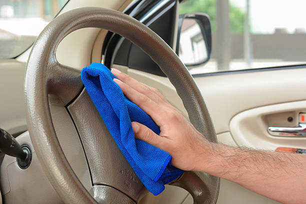 istock Hand cleaning car steering wheel with microfiber cloth 525023392