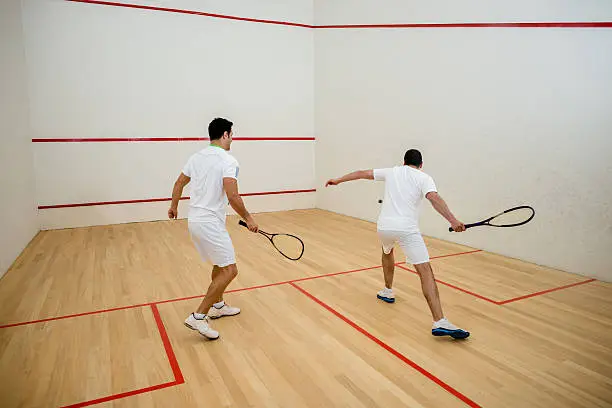 Two men playing squash in the court