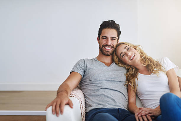 Being together is the best place to be Shot of a young couple relaxing at home couch potato photos stock pictures, royalty-free photos & images