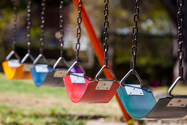Empty colorful swings at the park Empty colorful swings at the park play equipment stock pictures, royalty-free photos & images