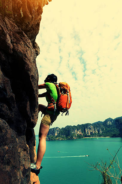 istock young woman rock climber climbing at seaside mountain cliff 525029090