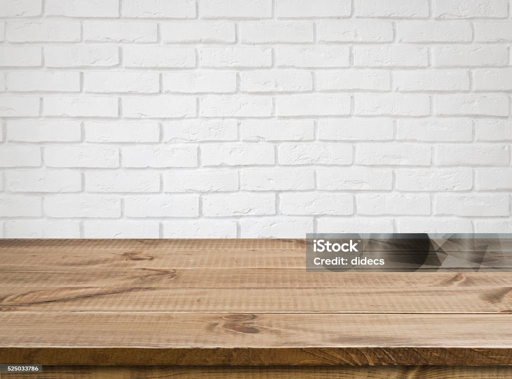 Rough wooden texture table over defocused white brick wall background Table Stock Photo
