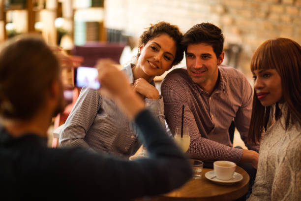 istock Smiling friends being photographed in a cafe. 525034706