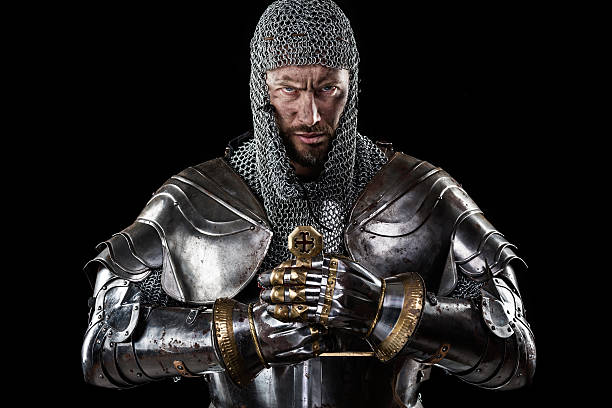 Medieval Warrior with Chain Mail Armour and Sword Portrait of Medieval Dirty Face Warrior with chain mail armour and red cross on sword. Black Background knight person photos stock pictures, royalty-free photos & images