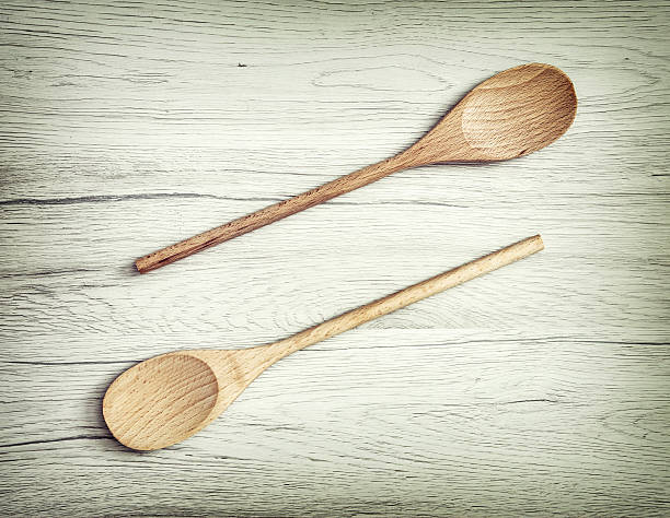 istock Two wooden spoons on the white background, kitchen equipment 525037288