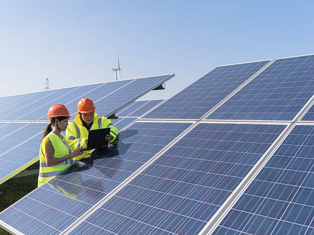 Future electrical production, asian engineers workers at a renewable energy plan, young asian engineers working in solar power station. asian female engineer stock pictures, royalty-free photos & images