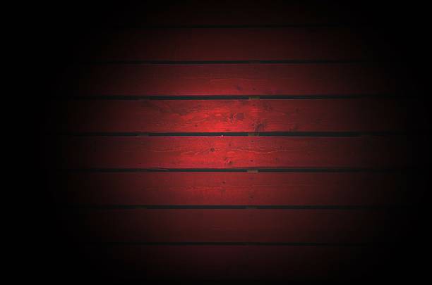 istock Old  dark red painted wooden wall  with light spot 525038282
