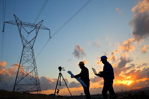 sylwetka inżynierów pracujących w stacji energii elektrycznej - pylon elektryczności zdjęcia i obrazy z banku zdjęć