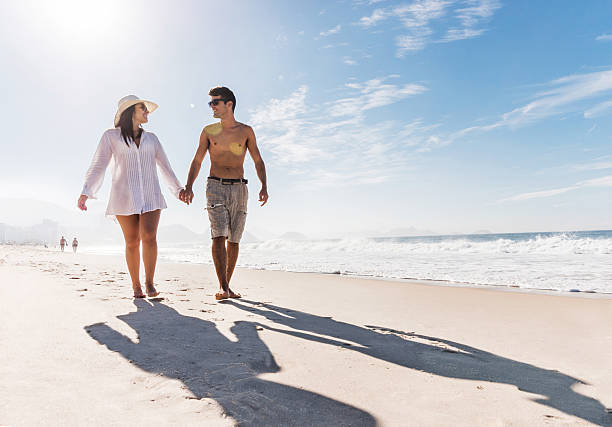istock Young Hispanic couple walking on the beach. 525040409