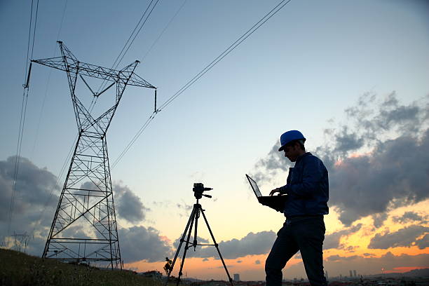 Electrical engineer while working laptopl Electrical engineer while working laptopl. monitoring electrical grid stock pictures, royalty-free photos & images