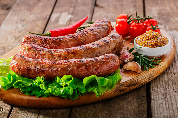 istock Grilled sausage on a board with vegetables and sauce 525042069