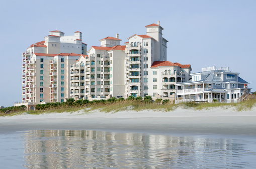 A row of oceanfront, upscale, condominiums and beach house. Taken just after sunrise with beautiful light and sky.