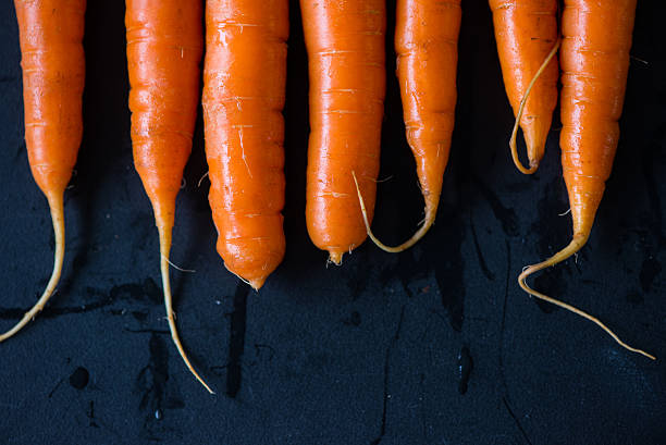 istock Farm clean and wet carrots on black background 525043989