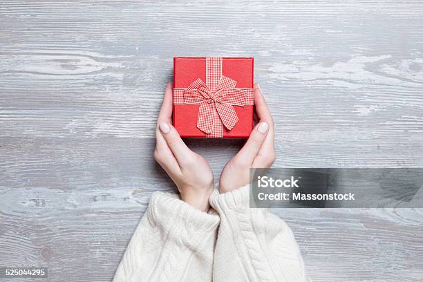 Mujeres Manos Sosteniendo Regalo En Mesa De Madera Foto de stock y más banco de imágenes de Agarrar