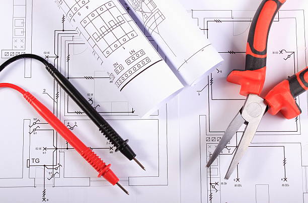 istock Electrical diagrams, cables of multimeter and metal pliers 525058491