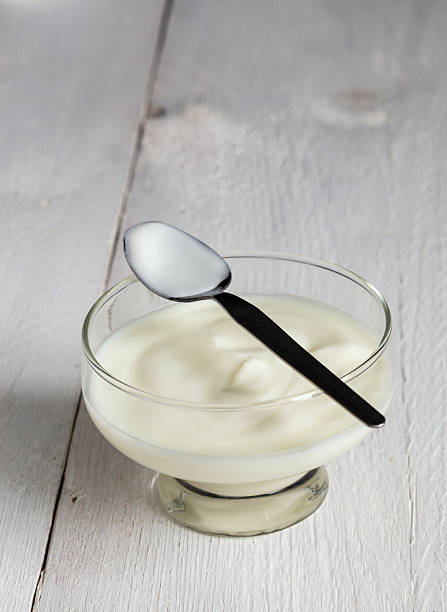 istock Natural yoghurt in glass with spoon on wood 525062141