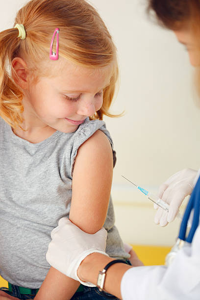 istock Doctor vaccinating small redhead girl. 525062559