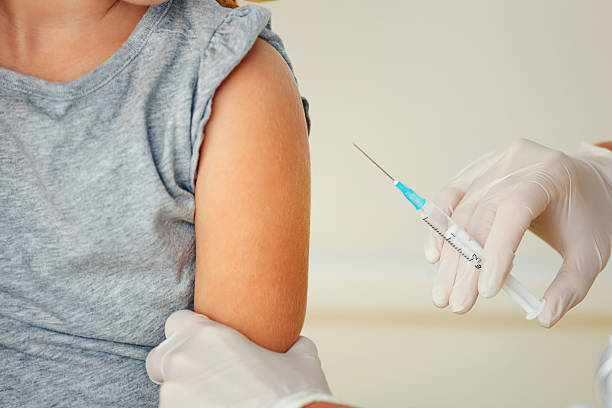 istock Doctor vaccinating small redhead girl. 525062561