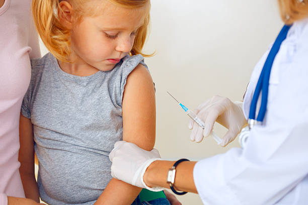 istock Doctor vaccinating small redhead girl. 525062565