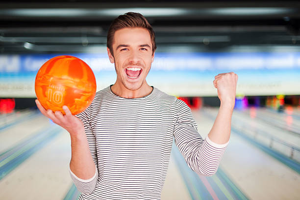 der champion beim bowling. - bowling holding bowling ball hobbies stock-fotos und bilder