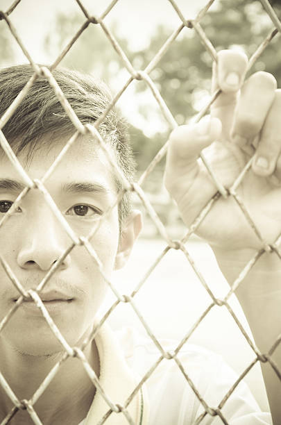 istock young man caged behind metal or steel net 525076721