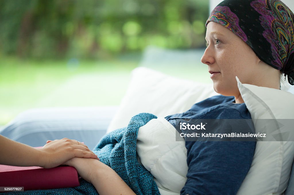 Cancer woman Cancer woman lying in bed supported by mum Cancer - Illness Stock Photo