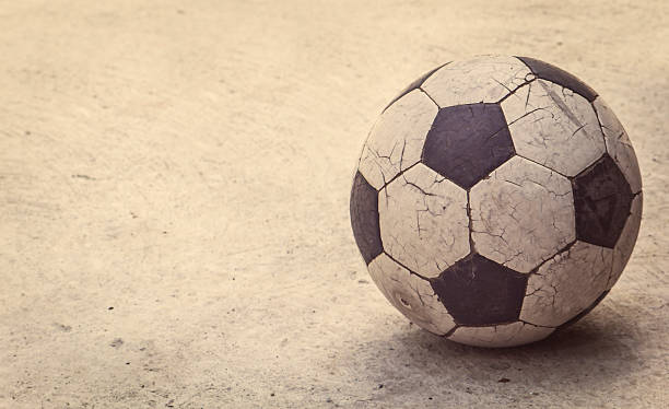 stary piłka nożna na beton tle, - soccer ball old leather soccer zdjęcia i obrazy z banku zdjęć