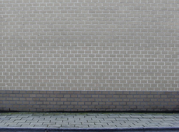 istock large section of a gray brick wall with sidewalk 525111071