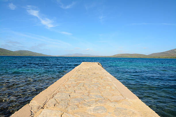 istock rocky pier in Porto Conte under a blue sky 525111335