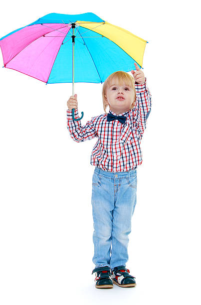 istock Little boy stands under a colorful umbrella. 525123565