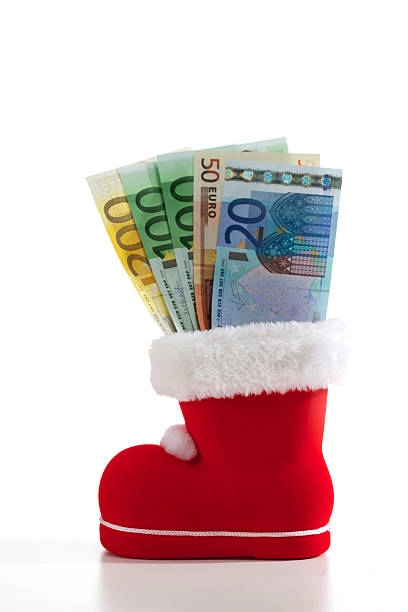 Santa Claus boot filled with euro notes on white background Santa Claus boot filled with euro notes on white background. euro bill in a christmas ornament stock pictures, royalty-free photos & images