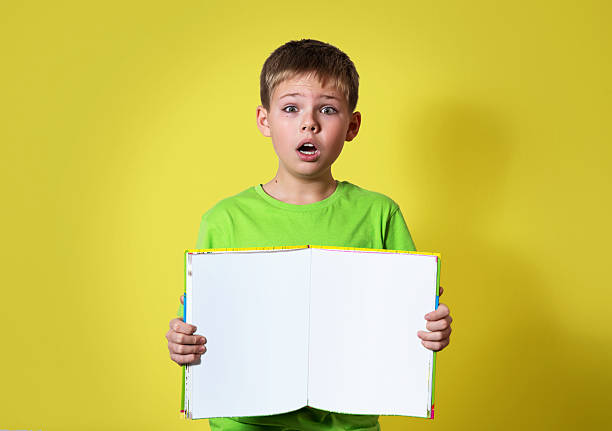 istock Shocked surprised boy holding book with empty copy space. Education. 525139773
