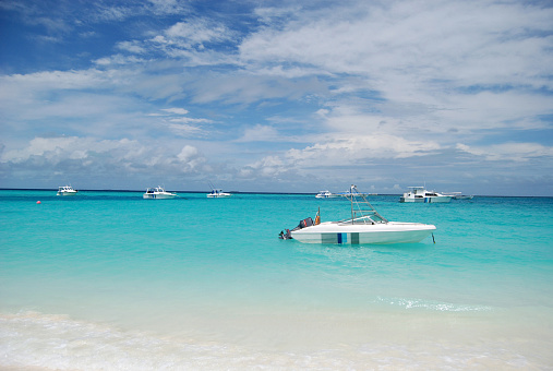 Boats anchored off Maldives on clean blue water.