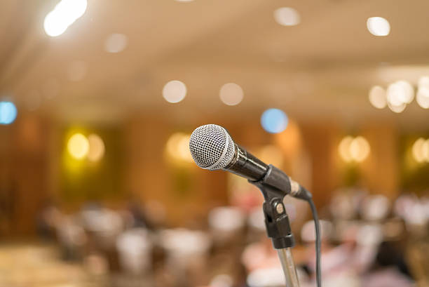 istock microphone in concert hall or conference room lights background 525142399