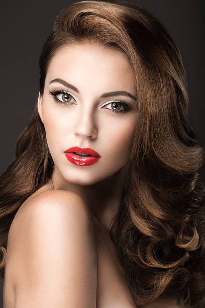 istock Beautiful woman with evening make-up, red lips and curls. 525156099