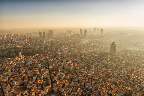 High angle view of western side of Istanbul with new modern buildings rising up next to traditional apartments. Backlit image shot against the sun, with copy space above.