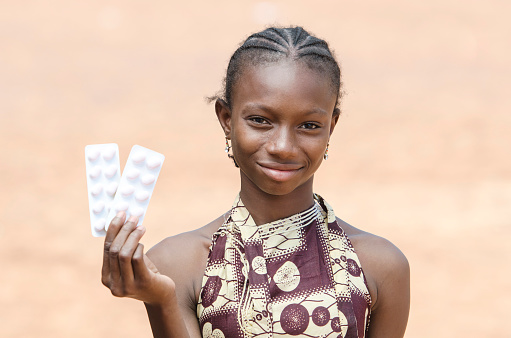 African young girl showing pills for medicine & healthcare projects in Bamako, Mali (Africa).