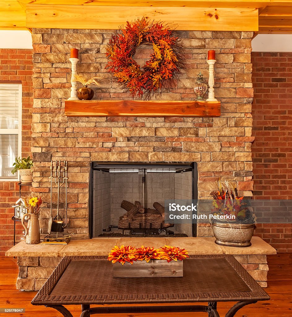 Outdoor Deck with Fireplace Covered backyard deck at residential house with gas fireplace, decorations for the season of autumn. Autumn Stock Photo