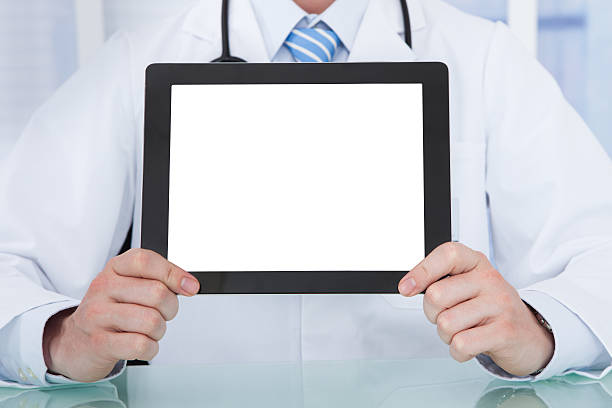 istock Doctor Displaying Digital Tablet At Desk 525178299