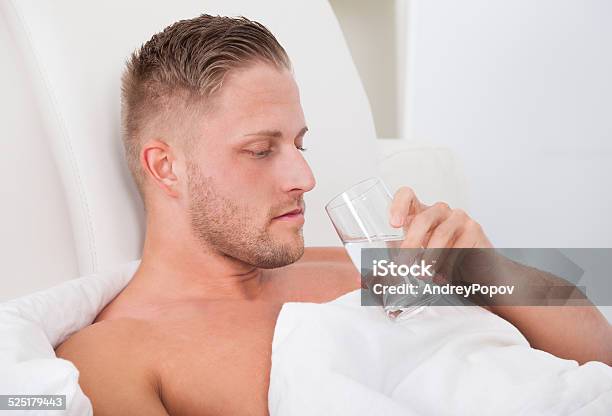 Man Drinking A Glass Of Water In Bed Stock Photo - Download Image Now - Adult, Bed - Furniture, Bedroom