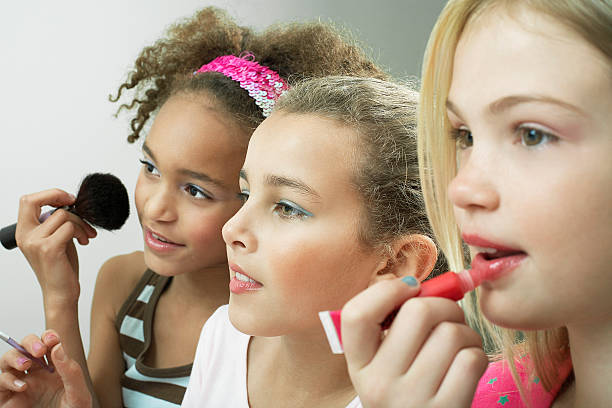 Girls Putting On Makeup And Lipgloss Stock Photo - Download Image Now - Pre- Adolescent Child, 10-11 Years, Activity - iStock