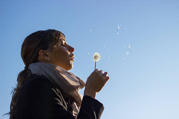 istock Girl blowing dandelion 525193767