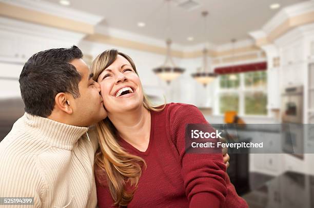Mixed Race Couple Kissing Inside Beautiful Custom Kitchen Stock Photo - Download Image Now